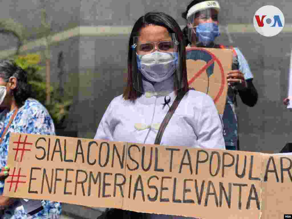 La pancarta de esta enfermera hace referencia a la consulta popular opositora convocada como respuesta a las elecciones parlamentarias en diciembre. Foto: &#193;lvaro Algarra, VOA. 