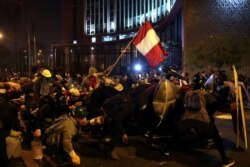 Manifestantes chocan con la policía durante las protestas que llevaron a la renuncia del presidente interino de Perú, Manuel Merino, en Lima. Fotografía tomada en noviembre de 2020.