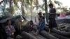 FILE - Rohingya stand on chopped trees in the Naybara refugee camp in Cox's Bazar, Dec. 3, 2017.
