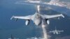 A Romanian Air Force F- 16s military fighter jet, in front, and a Portuguese Air Force F- 16s military fighter jets participating in NATO's Baltic Air Policing Mission operate over the Baltic Sea, Lithuanian airspace, Monday, May 22, 2023. (AP Photo/Mindaugas Kulbis)