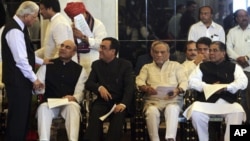 Ashwini Kumar, left, a junior minister, greets Pallam Raju, who moved from Defense to Human Resources Development ministry at the swearing-in ceremony, New Delhi, India, October 28, 2012.