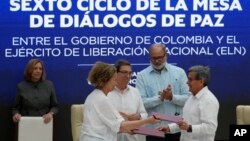 ARCHIVO - La representante del gobierno colombiano Vera Grabe, izquierda, y el comandante colombiano del grupo guerrillero ELN, Pablo Beltrán, intercambian su acuerdo firmado de extensión del alto el fuego en La Habana, Cuba, el 6 de febrero de 2024.
