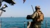 Un militar estadounidense, a bordo de uno de los buques de combate del submarino USS Georgia, observa las aguas durante una misión de reconocimiento en el estrecho de Ormuz, el 23 de diciembre de 2020.