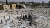 FILE - Pupils walk on debris of a damaged school in al-Saflaniyeh in eastern Aleppo's countryside, Syria, Sept. 17, 2017. 