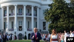 El presidente de EE.UU., Donald Trump en los jardines de la Casa Blanca en Washington DC acompañado de la primera dama Melania Trump, el 4 de julio de 2020.