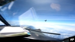 En esta imagen de un video proporcionado por la Marina de los EEUU, un caza J-16 chino vuela agresivamente cerca de un avión RC-135 de EEUU que vuela en el espacio aéreo internacional sobre el Mar de China Meridional el viernes 26 de mayo de 2023.