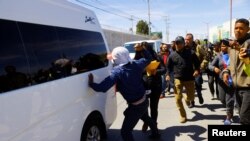 Migrantes protestan contra la política migratoria del gobierno mexicano durante la visita del presidente mexicano, Andrés Manuel López Obrador, a Ciudad Juárez. 