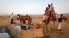 Tourists sit on a camel as it takes a drink of water at Pushkar Fair in the desert Indian state of Rajasthan November 23, 2012. Many international and domestic tourists throng to Pushkar to witness one of the most colourful and popular fairs in India. 