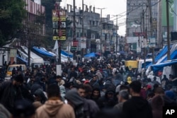Los palestinos compran suministros en el mercado de Rafah, Franja de Gaza, el domingo 18 de febrero de 2024. (Foto AP/Fátima Shbair)