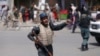 An Afghan policeman stands guard after an explosion near the police headquarters in Kabul, Afghanistan, Aug. 7, 2019. 