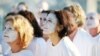 FILE - Demonstrators from the environmental group Greenpeace paint their faces white to highlight coral bleaching in Sydney, Friday, April 22, 2016. 