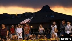 People listen at a prayer vigil ceremony for the 19 firefighters killed in a nearby wildfire in Prescott, Arizona, July 2, 2013.