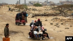 Personas viajan en la parte trasera de un triciclo que los transporta desde Nuseirat a la ciudad de Gaza el 10 de febrero de 2025, mientras palestinos desplazados regresan a sus hogares en medio del actual acuerdo de alto el fuego en la guerra entre Israel y Hamás.