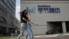 FILE - In this Aug. 7, 2020, file photo, women wearing masks to prevent the spread of the coronavirus chat as they pass by the headquarters of ByteDance, owners of TikTok, in Beijing, China.