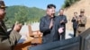 This image made from video aired by North Korea's KRT, July 4, 2017, shows what was said to be North Korea leader Kim Jong Un, center, applauding after the launch of a Hwasong-14 intercontinental ballistic missile in North Korea's northwest.