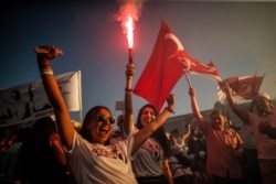 Supporters of Ekrem Imamoglu, the new Mayor of Istanbul from Turkey's main opposition opposition Republican People's Party (CHP) light a flare as he makes a speech after he took over office, in Istanbul, June 27, 2019.