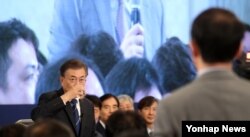 문재인 한국 대통령이 지난 17일 청와대에서 개최한 취임 100일 회견 도중 일본 기자의 질문을 들으며 물을 마시고 있다.