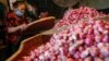 Seorang pedagang mengenakan masker wajah sedang memilah bawang di pasar tradisional di tengah pandemi virus corona (Covid-19) di Jakarta, 3 Agustus 2020. (Foto: Reuters)
