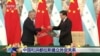 Los cancilleres de Honduras, Eduardo Enrique Reina García, a la izquierda, y el de China, Qin Gang, intercambian acuerdos durante una ceremonia de firma en Beijing, el 26 de marzo de 2023. (CCTV a través de AP)
