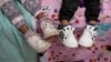 Dos hermanos de 7 y 3 años sentados juntos en una cama en la casa a la que la familia se mudó en octubre de 2023, cinco años después de huir de Venezuela a Colombia. La familia fue entre los primeros migrantes que ingresaron a EEUU bajo las "oficinas de movilidad segura".