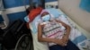 A young woman, who has a tumor in one of her lungs, lies in a bed in the Vargas Public Hospital in Caracas, Venezuela, Feb. 5, 2019. 