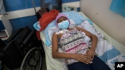 A young woman, who has a tumor in one of her lungs, lies in a bed in the Vargas Public Hospital in Caracas, Venezuela, Feb. 5, 2019. 