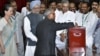Pranab Mukherjee casts his vote in India's presidential election as PM Singh and Congress party president Sonia Gandhi, along with other lawmakers look on in New Delhi, July 19, 2012. 