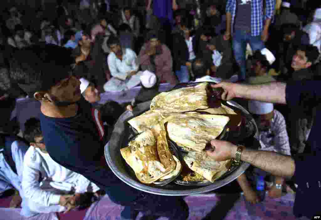 Muslim Afghanistan membagikan makanan saat berbuka puasa Ramadan di masjid Wazir Akbar Khan di Kabul.
