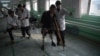 An Afghan doctor (R) assisting a survivor of a landmine blast at a hospital run by the International Committee of the Red Cross (ICRC) for war victims and the disabled in Kabul, Feb. 13, 2018.