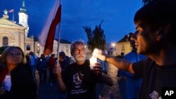 People light candles as they attend a daily protest against judicial reforms in Warsaw, Poland, July 27, 2017. 