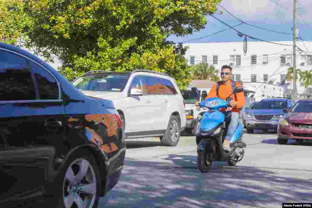 Un hombre conduce un scooter en medio del tráfico en Miami, el 25 de enero de 2023. La ciudad ha visto un incremento de estos vehículos en las calles, provocado por la llegada de una nueva ola migrantes que utilizan la &quot;motorina&quot; como alternativa de transporte mientras regularizan su estatus legal.