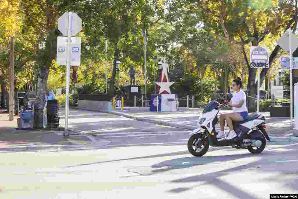 Una mujer conduce una &quot;motorina&quot; por la Calle 8 de la Pequeña Habana, en Miami, el 25 de enero de 2023. Los scooters se han convertido en un medio de transporte popular en Cuba, donde comprar un auto es casi imposible debido a los altos precios y el bajo poder adquisitivo de la gran mayoría. Ahora, los cientos de migrantes cubanos que han llegado a Miami han traído consigo esta &quot;cultura de la motorina&quot;.&nbsp;