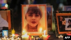 Velas e imágenes se muestran durante una vigilia por Mahsa Amini, quien murió bajo custodia de la policía de moralidad de Irán, en Los Ángeles, el 29 de septiembre de 2022.