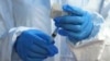 FILE - A health care worker from the World Health Organization prepares to administer an Ebola vaccine to a patient in Mangina, Democratic Republic of Congo, Aug. 8, 2018.