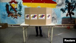 Una persona deposita su voto para las primarias del partido del Gobierno, de cara a las elecciones de noviembre, en Caracas, el 8 de agosto de 2021.