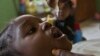 A volunteer health official immunises a child at a school in Nigeria's capital Abuja February 1, 2010. The WHO, UNICEF, and other aid agencies have been working since 1988 to eradicate polio, but their initial target of the year 2000 proved elusive. Four 