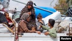 Palestinos viajan en un vehículo mientras huyen de Rafah después de que las fuerzas israelíes lanzaran una operación terrestre y aérea en el sur de Gaza. El 13 de mayo de 2024.