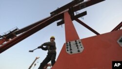中国建造高铁搞“大跃进”之后，隐患开始出现。图为安徽合肥一名工人2011年1月4日在进行高铁的高架桥施工