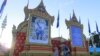 រូបឯកសារ៖ ភ្ញៀវ​ទេសចរ​ដើរ​កាត់​មុខ​ព្រះឆាយាលក្ខណ៍​ព្រះបរមនាថ​ នរោត្តម​ សីហមុនី​ ព្រះ​មហាក្សត្រ​នៃ​ព្រះរាជាណាចក្រ​កម្ពុជា​ ដែល​ត្រូវ​បាន​ដាក់​តាំង​នៅ​មុខ​វិមាន​ឯករាជ្យ​ក្នុង​ឱកាស​ខួប​ទី​១១​នៃ​ព្រះ​រាជ​ពិធី​បុណ្យ​​គ្រង​រាជ​សម្បតិ្ត​ កាល​ពី​ល្ងាច​ថ្ងៃ​ទី​២៨ ខែ​តុលា​ ឆ្នាំ​២០១៥។ (នូវ ពៅ​លក្ខិណា​/VOA) 