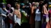 Sejumlah perempuan menggunakan masker wajah antre membeli sembako murah di Banda Aceh, 14 Mei 2020. (Foto: AFP)
