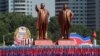 People carry flags in front of statues of North Korea founder Kim Il Sung, left, and late leader Kim Jong Il during a military parade marking the 70th anniversary of North Korea's foundation in Pyongyang, North Korea, Sept. 9, 2018.