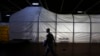 FILE - A U.S. marine officer walks past the Field Deployable Hidrolysis System (FDHS) of the U.S. MV Cape Ray ship docked at the naval airbase in Rota, near Cadiz, southern Spain.