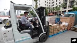 En esta fotografía del miércoles 3 de junio de 2020, un gerente del Supermercado Presidente usa una carretilla elevadora para mover un cargamento de comida en la tienda del barrio de La Pequeña Habana de Miami.