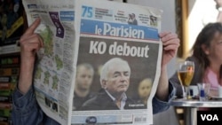 Una mujer lee el diario franceses "Le Parisien", cuya primera página muestra noticias sobre el director gerente del FMI.
