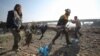 Un rescatista de los Cascos Blancos de Siria y un civil transportan el cuerpo de una víctima tras un ataque aéreo ruso en la autopista Damasco-Alepo cerca de Maaret añ-Numan en Idlib, en el sur del país, el 22 de diciembre de 2019. AFP/Haj Kadour.