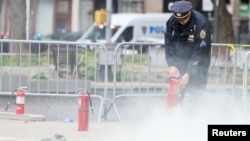 Cảnh sát New York xử lý hiện trường vụ một người đàn ông tự thiêu bên ngoài tòa án hôm 19/4.