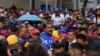 El presidente venezolano, Nicolás Maduro, saluda a jóvenes partidarios que marchan contra las sanciones impuestas por Estados Unidos a Venezuela, en Caracas, el viernes 17 de mayo de 2024.