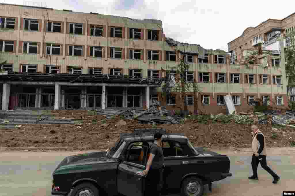 Un residente de Bakhmut, en la región de Donetsk, en el este de Ucrania, camina frente a un edificio universitario semidestruido por un ataque de cohetes, el 21 de mayo de 2022.&nbsp;
