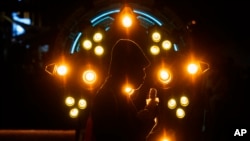FILE - A person eats while walking past a spacecraft at an exhibition about "The Three-Body Problem" in Chengdu, China, Oct. 20, 2023. The makers of "Game of Thrones" have adapted the book trilogy written by Liu Cixin as a Netflix series, "3 Body Problem."