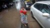A boy sells roses while standing on a road divider during in Mumbai in this July 12, 2013, file photo.
